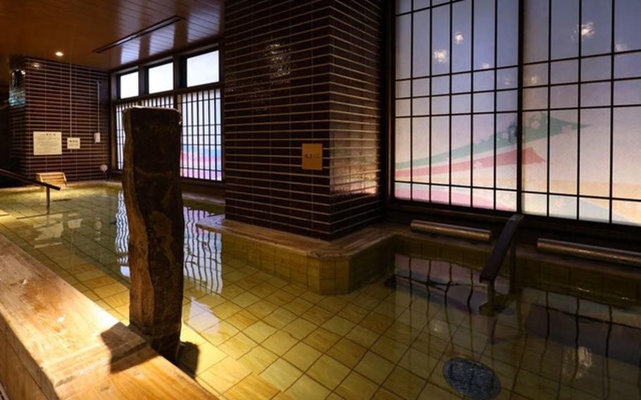 An empty interior pool is lined by windows.
