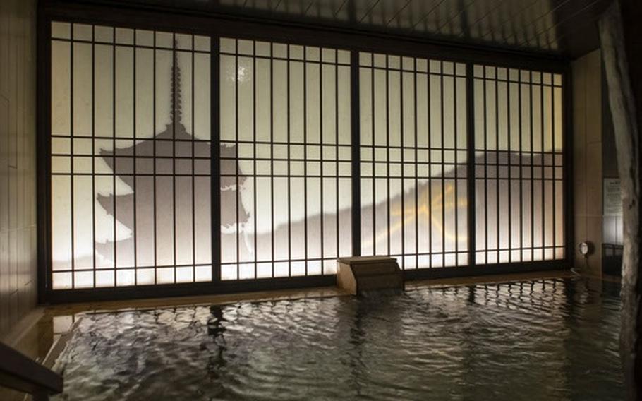A building interior shows a dimly lit pool while the outline of a pagoda is visible outside.