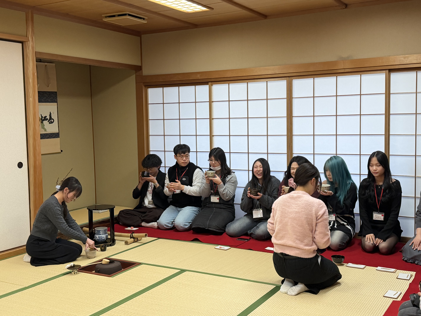Korean students sitting on their knees learn how to drink matcha tea properly during a tea ceremony lesson at Tezukayama Gakuin University in Osaka, Japan, on Jan. 22. [LEE SOO-JUNG]
