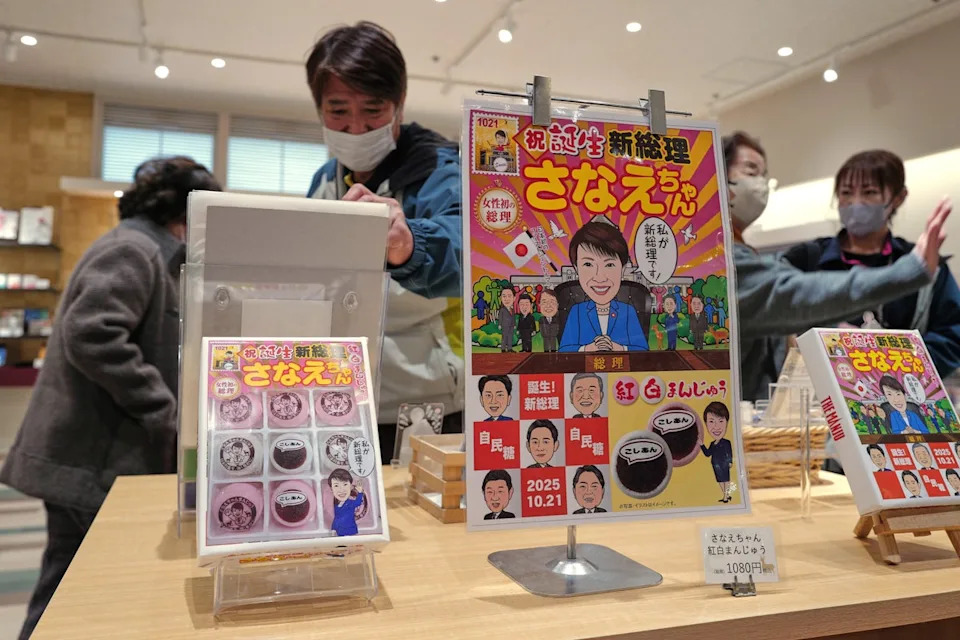 FILE- Visitors look at souvenir items featuring Japanese Prime Minister Sanae Takaichi at a shop in Nara, Takaichi's hometown, western Japan, Jan. 13, 2026. (AP Photo/Eugene Hoshiko, File) (Copyright 2026 The Associated Press. All rights reserved)