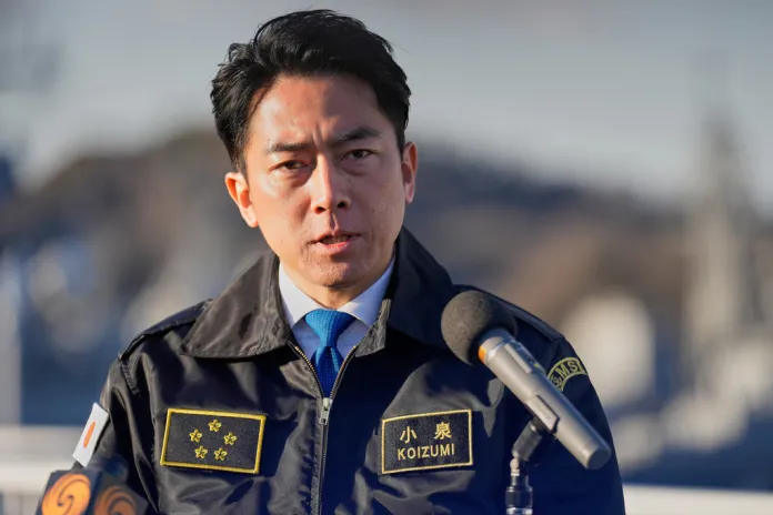 Koizumi speaks to reporters from a podium