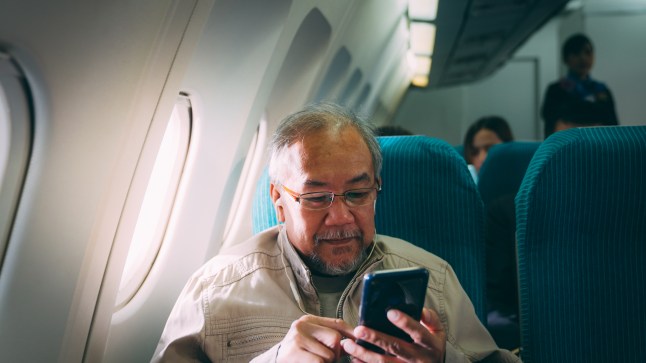 Senior Man Using Smart phone during the flight