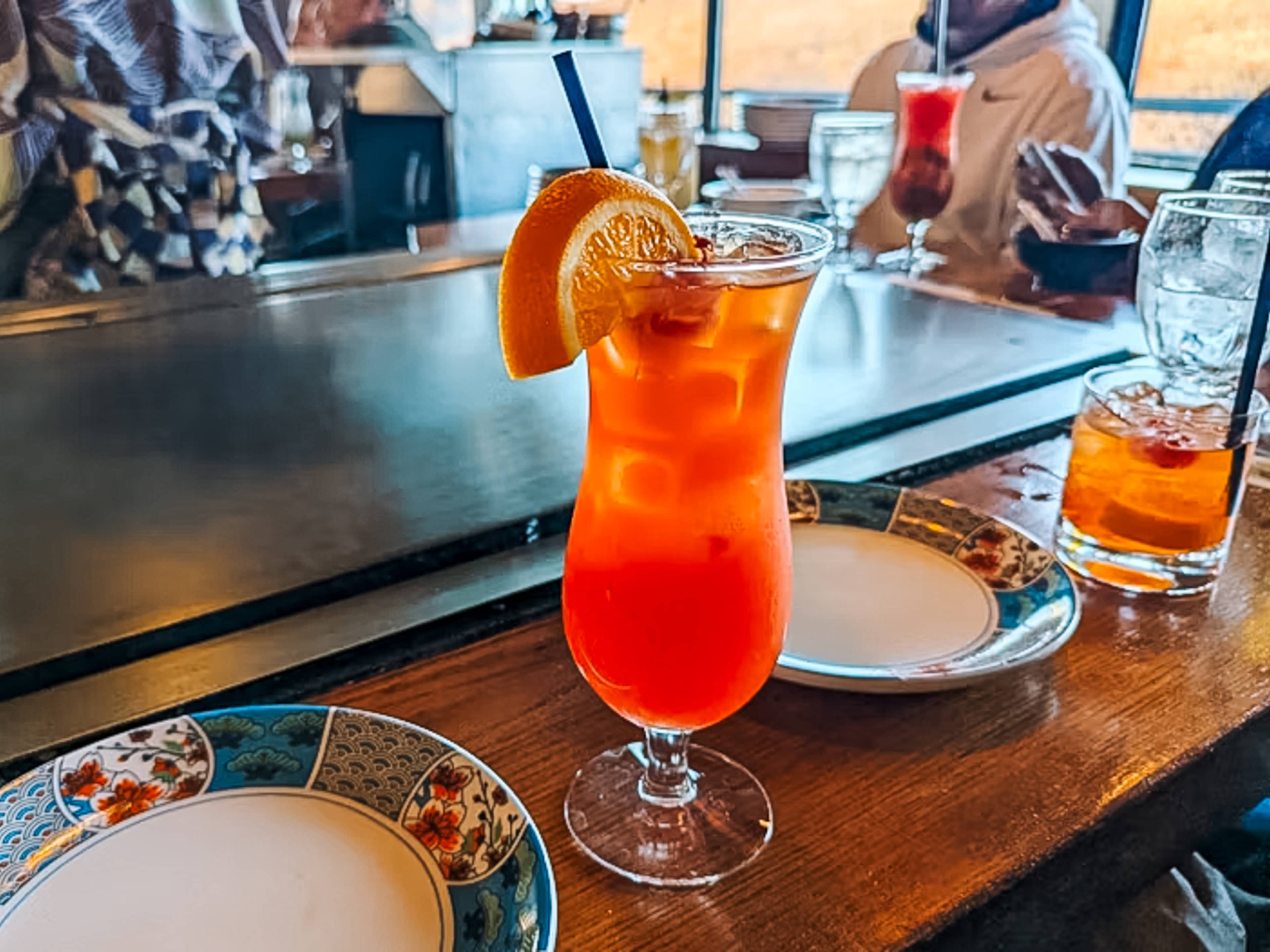 orange-colored Mai Tai with an orange wedge stuck in it