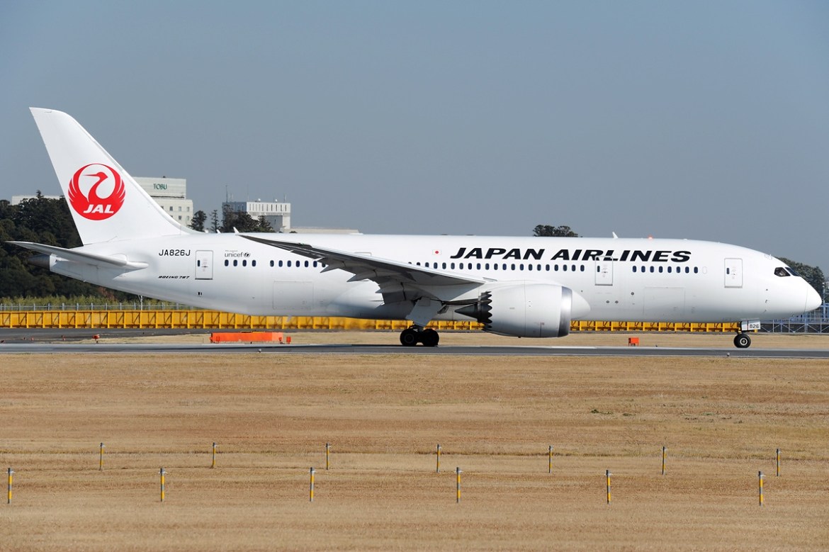 A Japan Airlines Boeing 787 Dreamliner with its distinctive scalloped engine nacelles taxis on a runway.