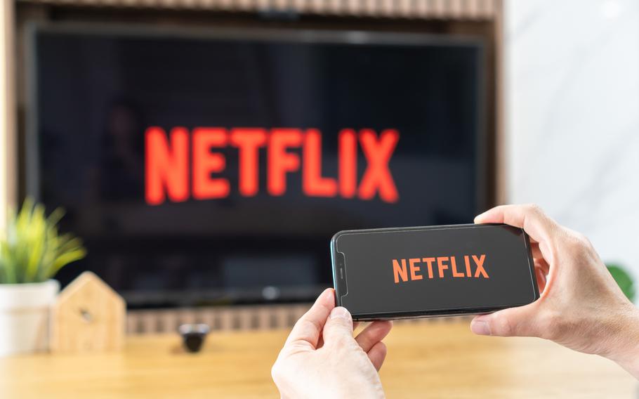 Netflix app logo on ipad and TV screen sharing in home dining room during new normal lifestyle