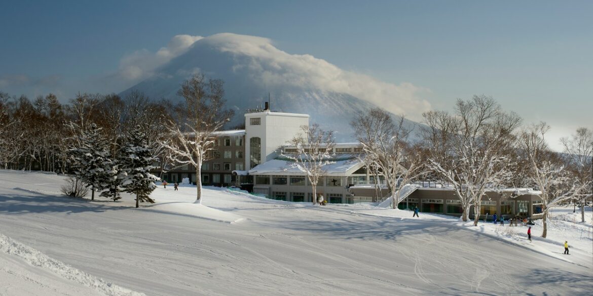 The Green Leaf Niseko Village, Tapestry Collection by Hilton, Opens in Hokkaido the hotel seen from a distance with snowy landscape in front and mountain behind