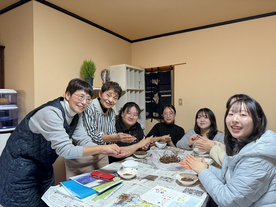 Five Korean undergraduates and their host family members polish leaves at a kitchen during their home-stay experience in Tokushima Prefecture in Japan on Jan. 25. [LEE SOO-JUNG]