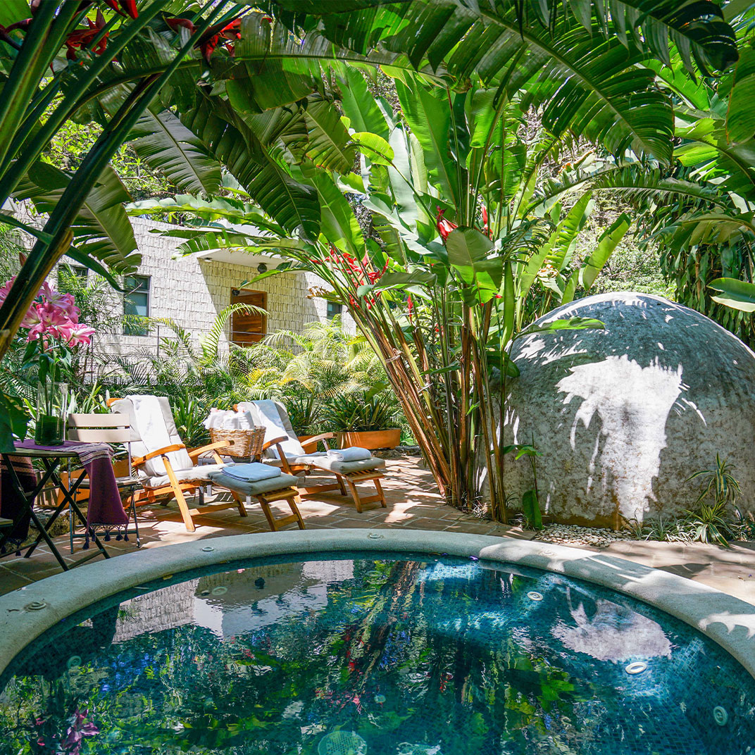 The entrance to Amomoxtli takes you over a 200-year old stone bridge framed by tropical garden. © Amomoxtli