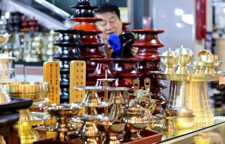 A merchant arranges a set of  utensils for ancestral rites ahead of the Lunar New Year holiday at Seomun Market in  Daegu, Feb. 3. Newsis