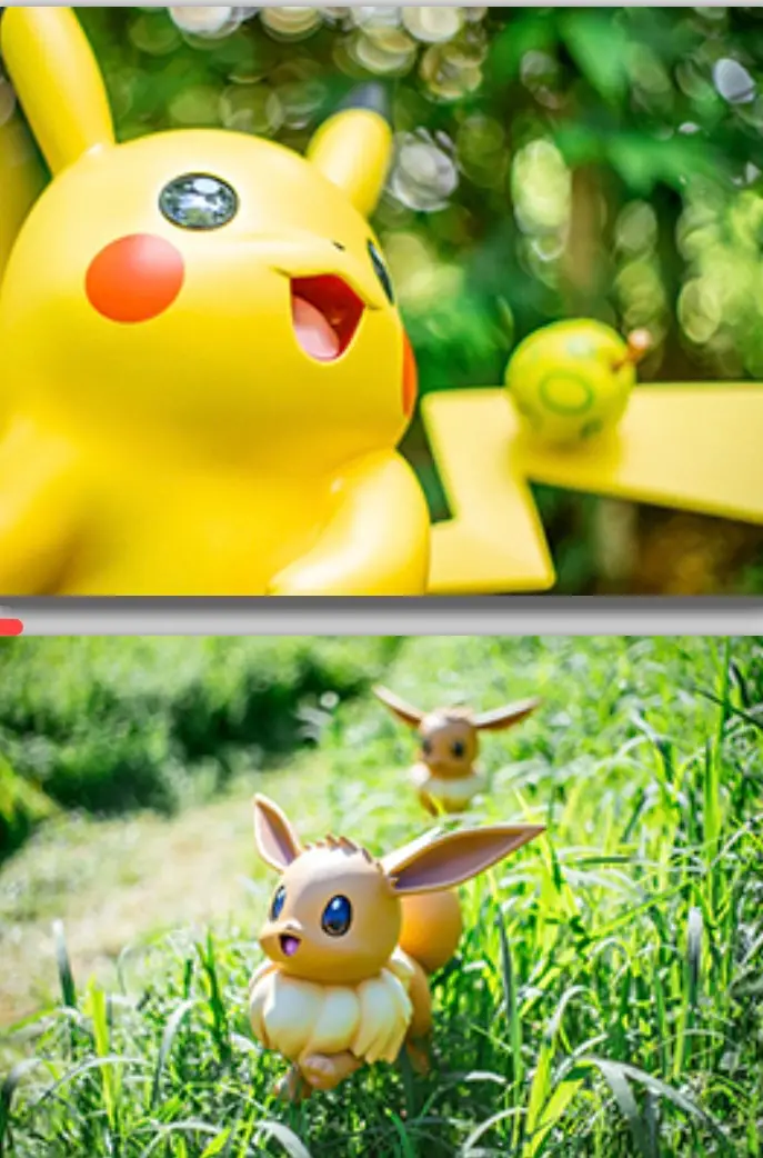 World’s First Outdoor Pokémon Theme Park Opens In Japan, Tickets Sold Out Till April 3 Close-up of Pikachu figure smiling in a green outdoor setting, with Eevee character running through tall grass below