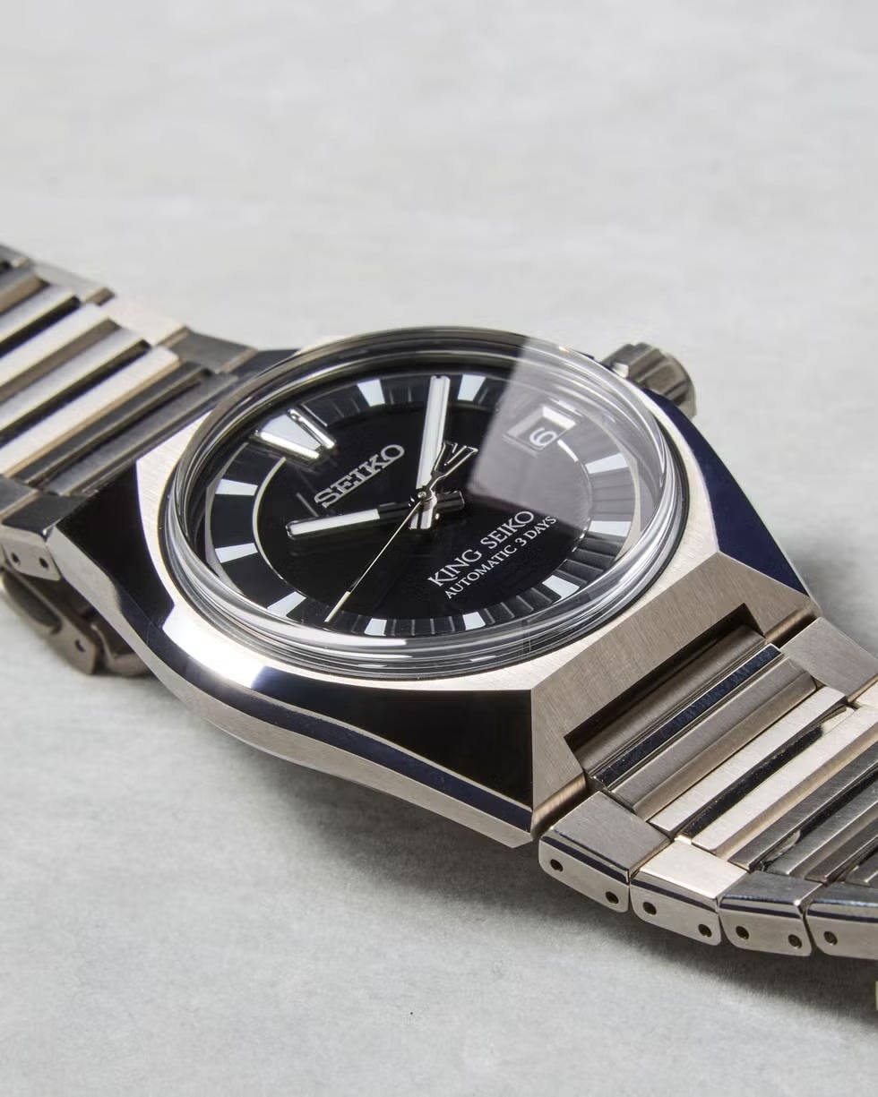 luxury automatic watch with a black dial and stainless steel band