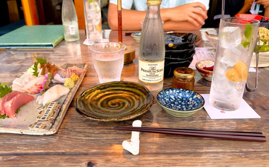 A table setting includes water bottles, a plate, a bowl and a set of chopsticks.