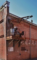 A crane that was used for loading and unloading cargo onto and from freight trains that directly entered the passageway between the warehouse buildings is seen in the city of Osaka's Minato Ward, Feb. 19, 2026. (Mainichi/Masashi Mimura)