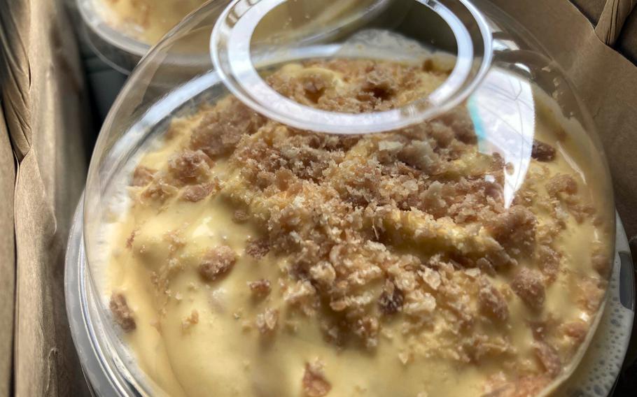 A closeup of the top of a cold coffee beverage shows cream and toppings.