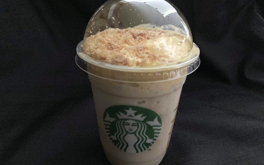 A cold, lidded coffee drink sits on a dark table.