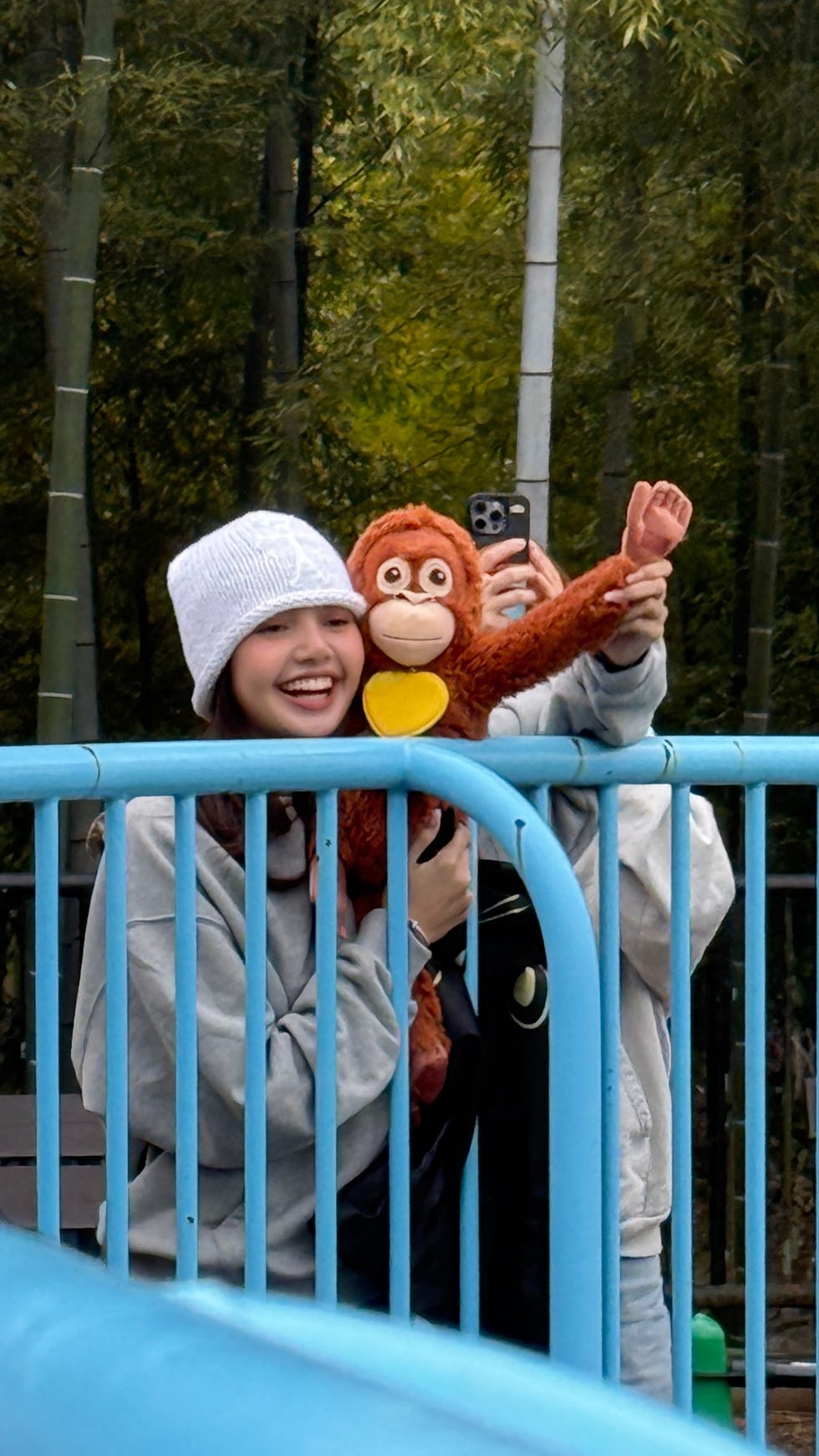 Individuals holding a stuffed toy at a park