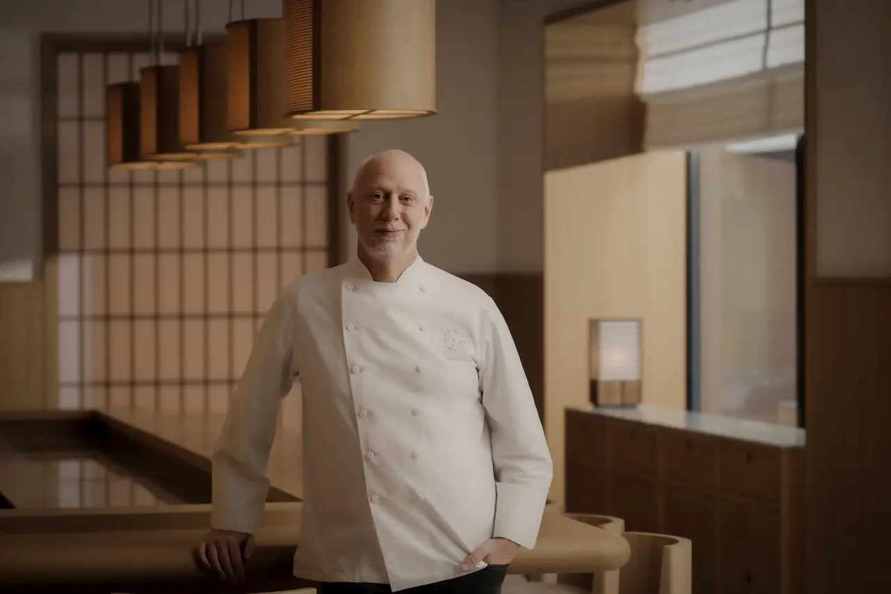 Chef standing in SoNoMa restaurant at Capella Kyoto with minimalist Japanese interior and warm lighting