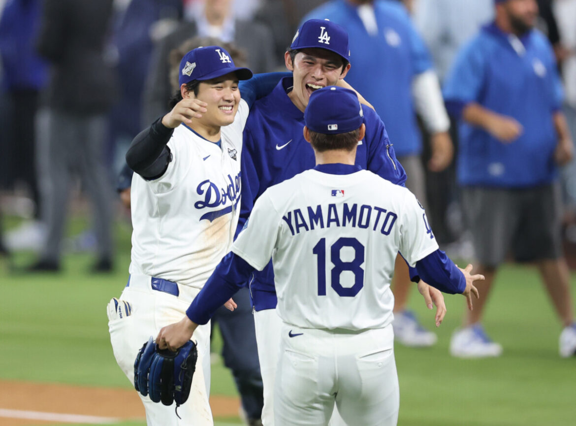 Oct 27, 2025; Los Angeles, California, USA; Los Angeles Dodgers designated hitter Shohei Ohtani (17) celebrates with pitcher Roki Sasaki (11) and pitcher Yoshinobu Yamamoto (18) after winning in the eighteenth inning against the Toronto Blue Jays in game three of the 2025 MLB World Series at Dodger Stadium. Mandatory Credit: Kiyoshi Mio-Imagn Images