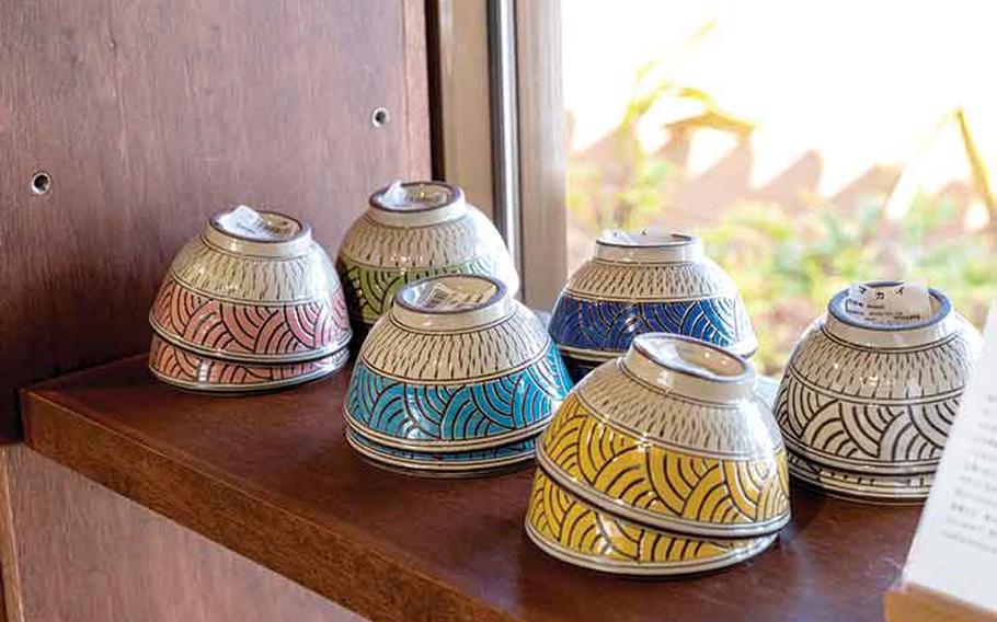 Some rice bowls are displayed on a shelf.