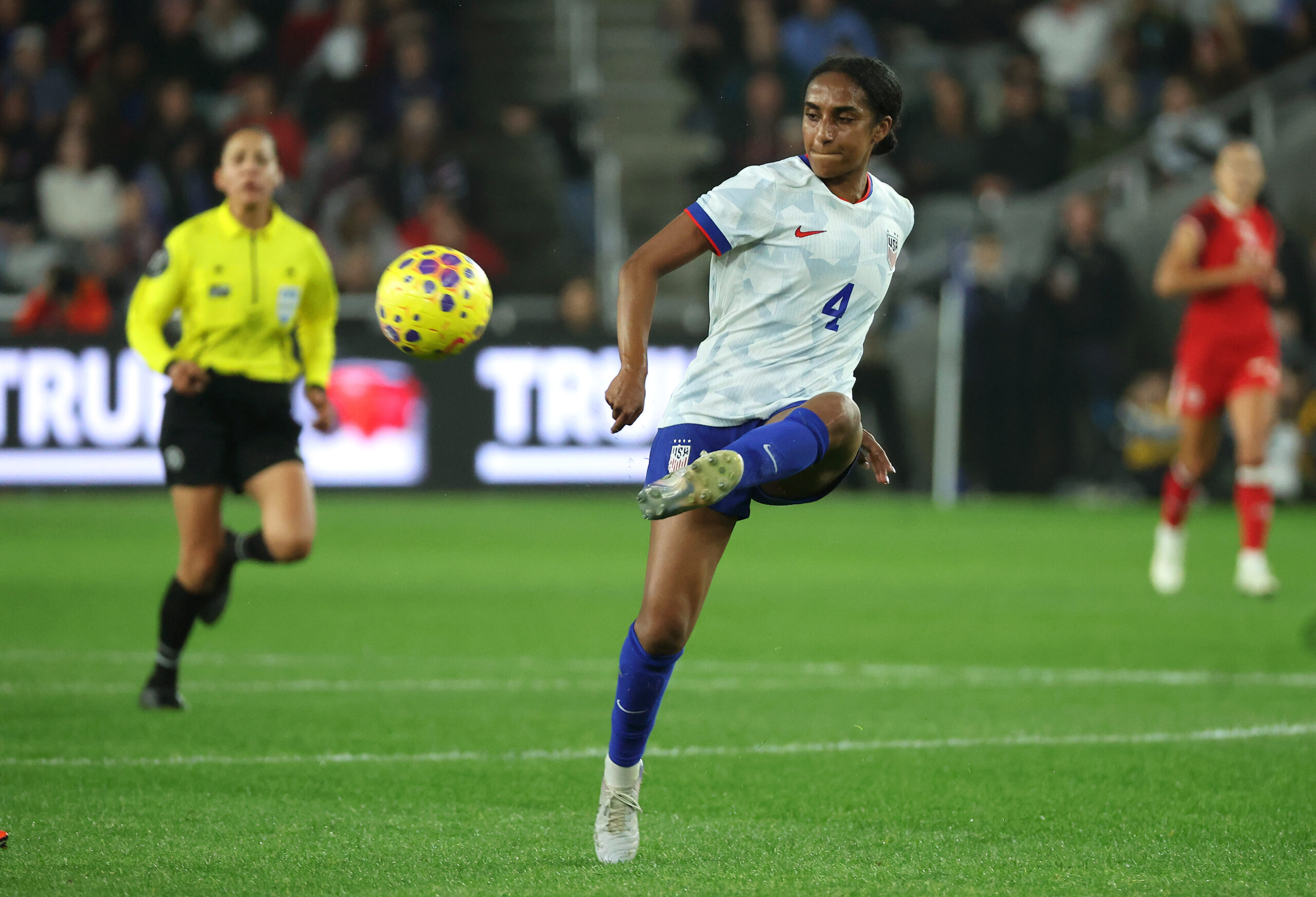 Naomi Girma kicks a soccer ball.