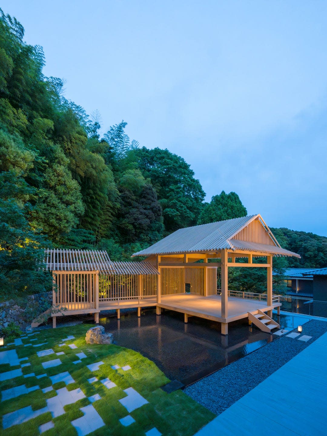 traditional japanese pavilion surrounded by lush greenery and water