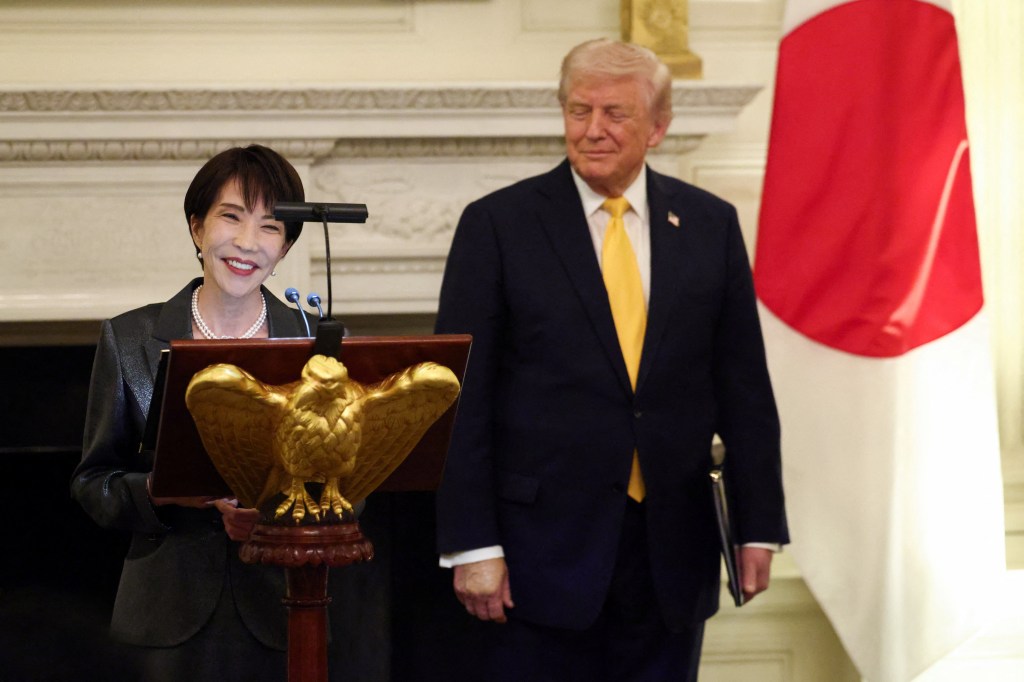 Japanese Prime Minister Sanae Takaichi delivering remarks with U.S. President Donald Trump standing nearby.