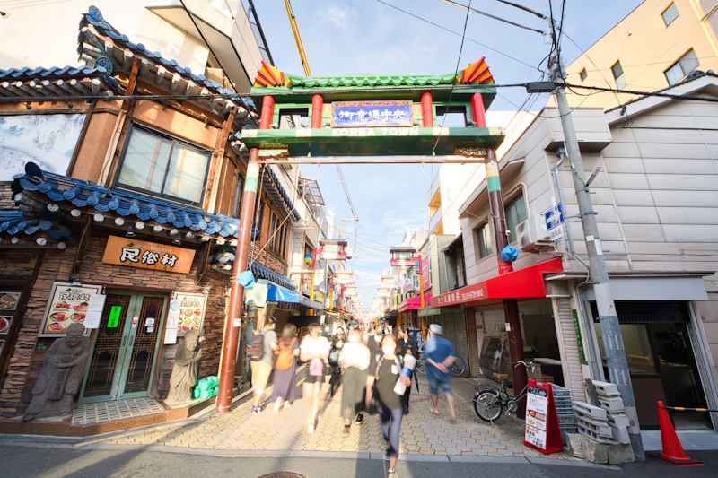 People walking into and out of the gate in Osaka's Ikuno Ward