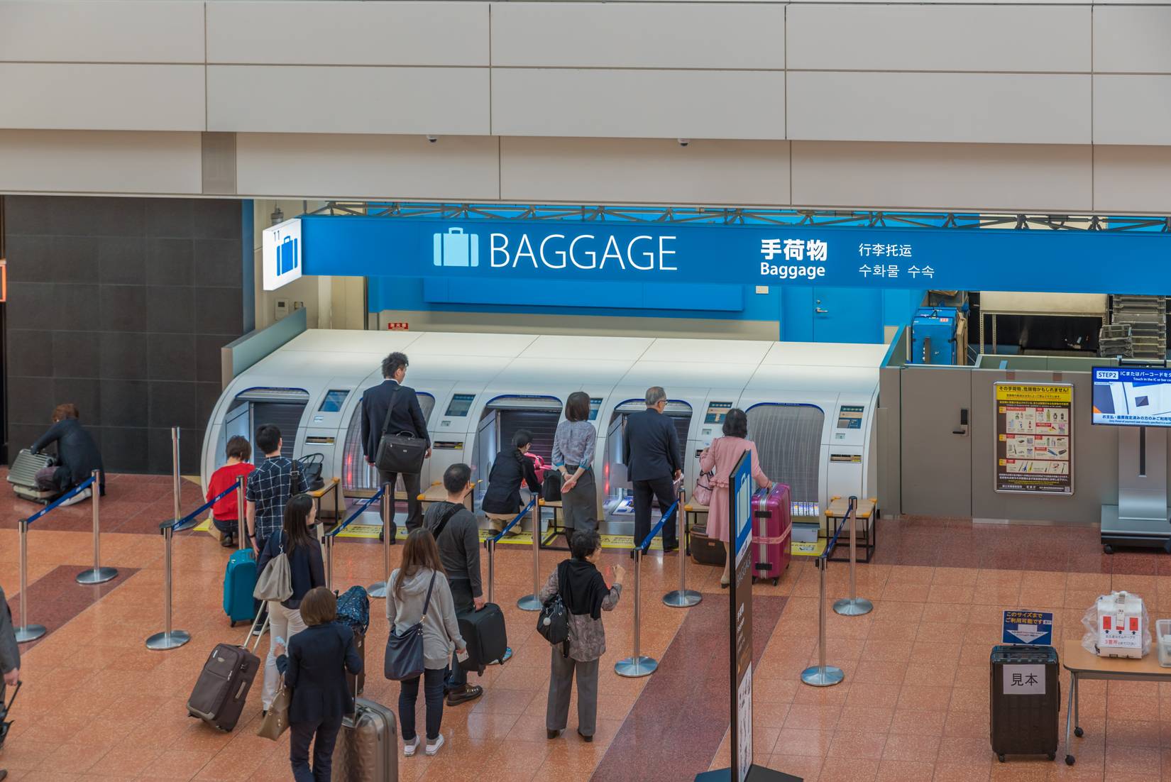 Travelers line up behind terminal 2 of Tokyo International Airport in Japan
