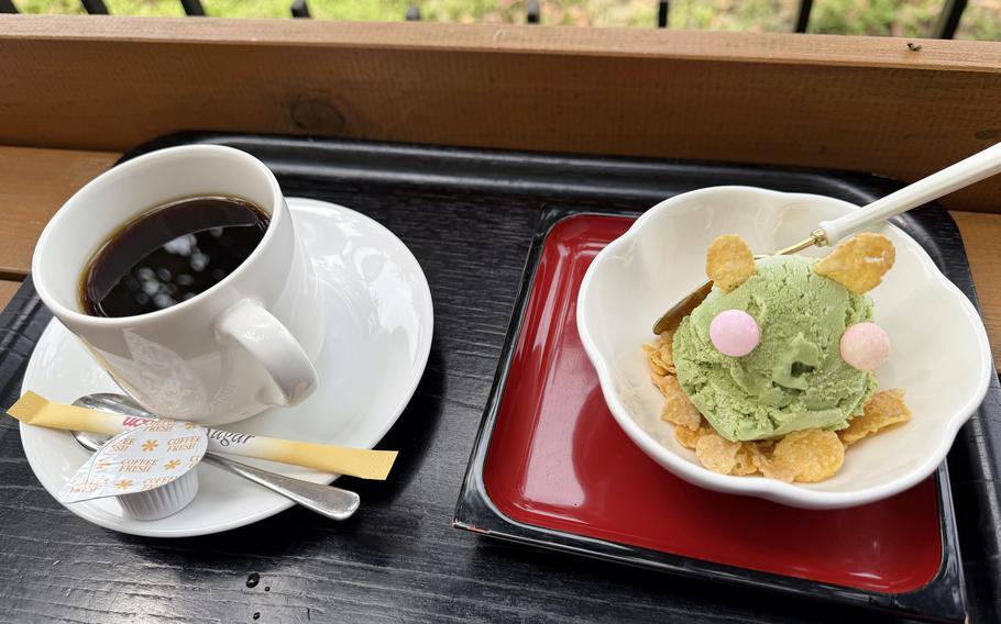 A cup of coffee and green ice cream sit on a table.