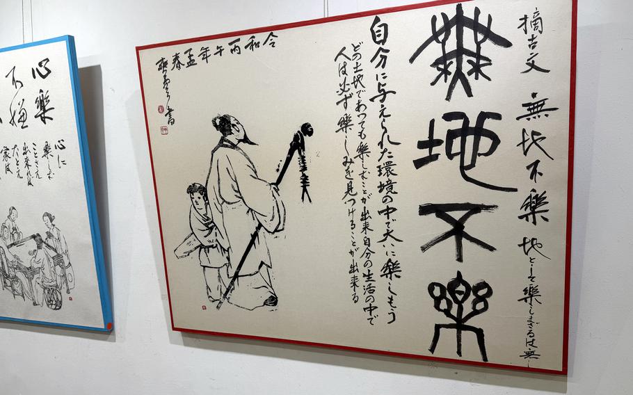 Calligraphy art is hanging on a wall.