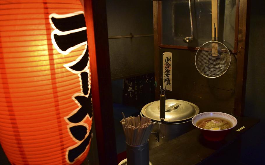 A paper lantern illuminates two bowls of ramen.