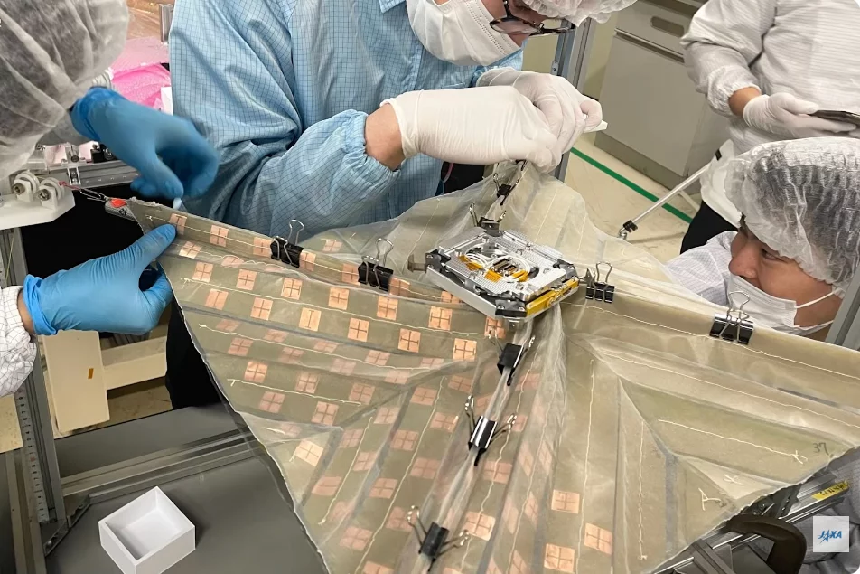 The CubeSat's folding two-layer membrane is prepared for stowage prior to launch