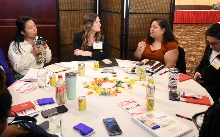 Military spouses sit together at a round table.