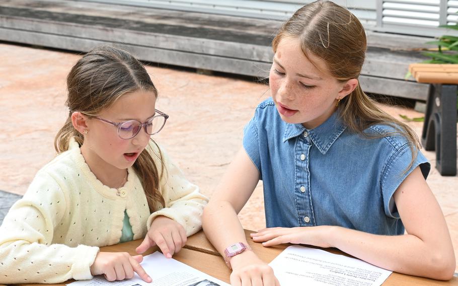 Two grade school girls read over school papers.