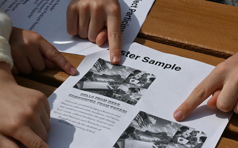 Two sets of hands point at papers on a table.