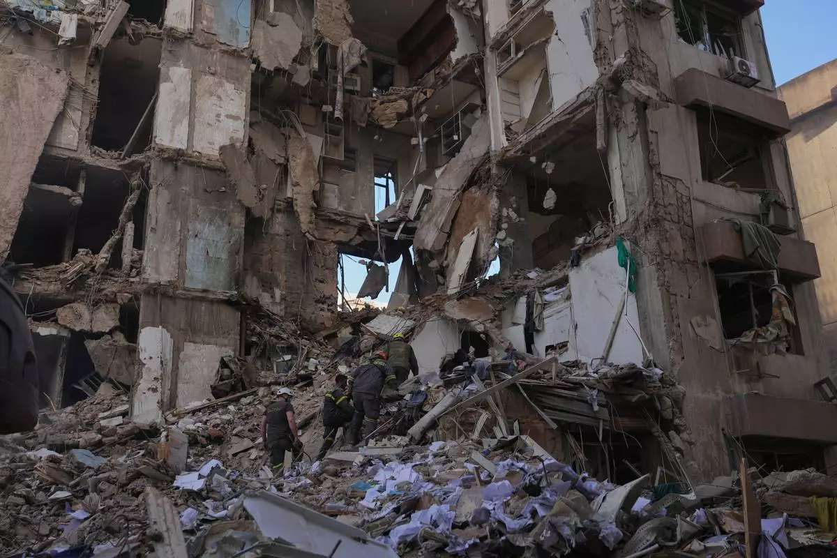 Lebanese civil defense workers search for victims in the rubble of a building destroyed in an Israeli airstrike a day earlier in central Beirut, Lebanon, Thursday, April 9, 2026. (AP Photo/Hassan Ammar)