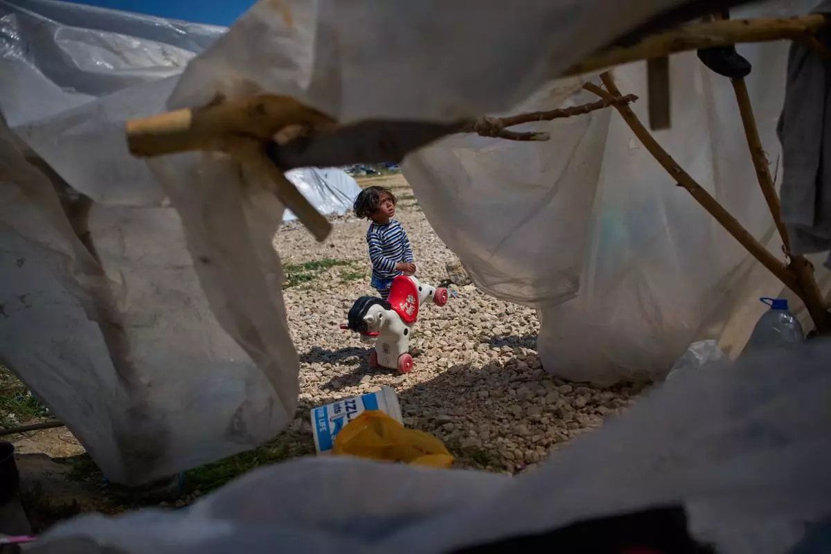 Ali, 4, holds a toy horse next to the tent his family uses as a shelter after fleeing Israeli bombardment in southern Lebanon, in Beirut, Lebanon, Wednesday, April 8, 2026. (AP Photo/Emilio Morenatti)