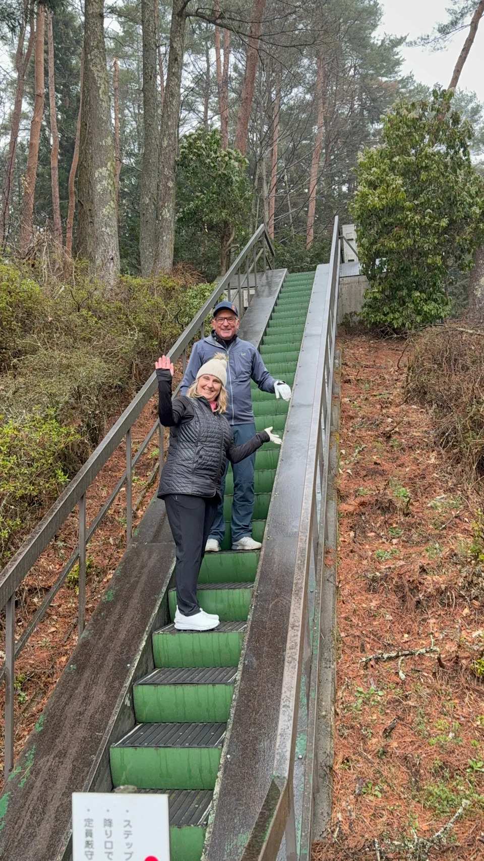 Man and woman on an outdoor escalator going up a hill