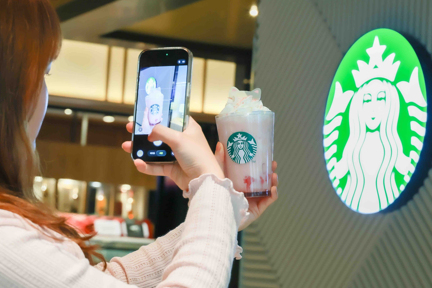 A customer takes a photo of the Cherry Blossom White Peach Frappucino [STARBUCKS KOREA]