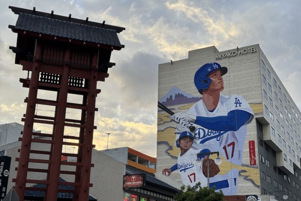 Little Tokyo streetscape featuring a large Shohei Ohtani mural on the Miyako Hotel alongside a traditional red tower structure.