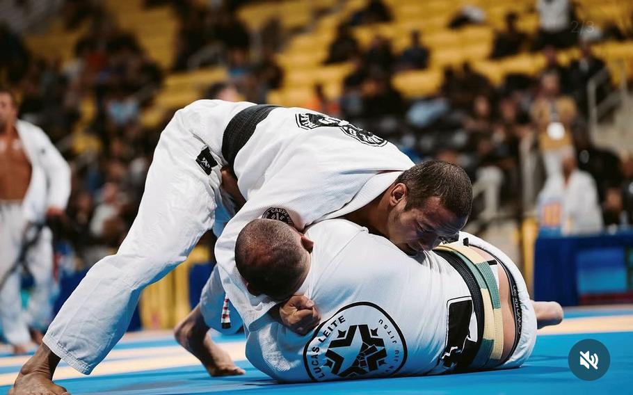 Two men do jiu jitsu.