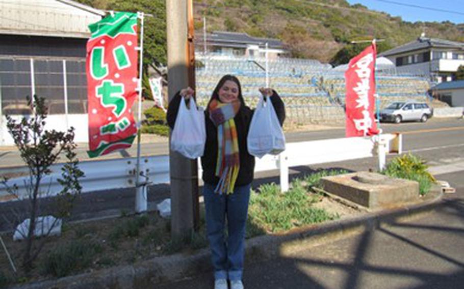 Holding plastic bags full of strawberries.