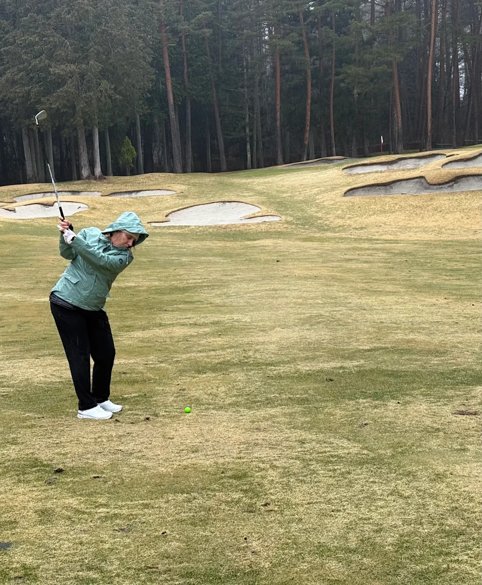Golfer taking a shot up a hill full of bunkers