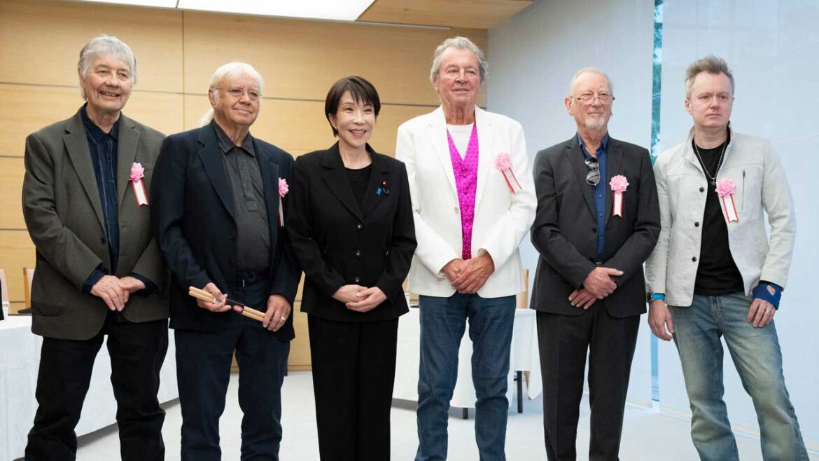 Japan's Prime Minister Sanae Takaichi poses with members of Deep Purple during their meeting the Prime Minister's Office in Tokyo on April 10, 2026