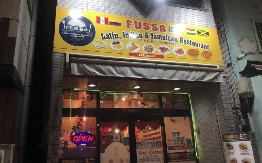 A restaurant exterior shows a sign and glass windows and doors.