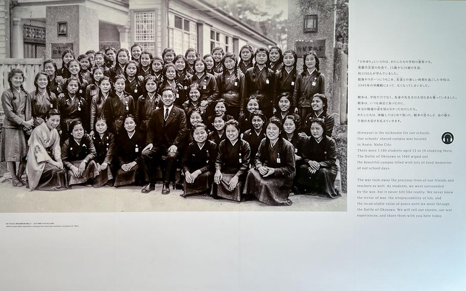 An old, black-and-white photograph shows young women posing for a school photo.