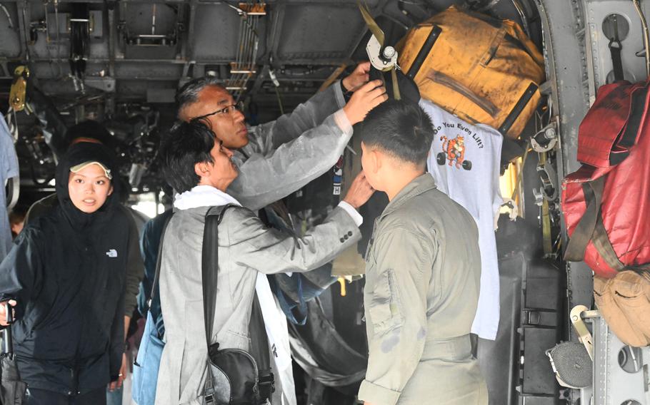 Guests examine the inside of a Marine Corps MV-22 Osprey tiltrotor aircraft.