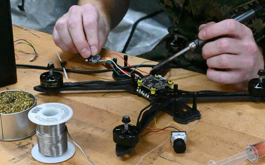 A Marine solders electrical components.