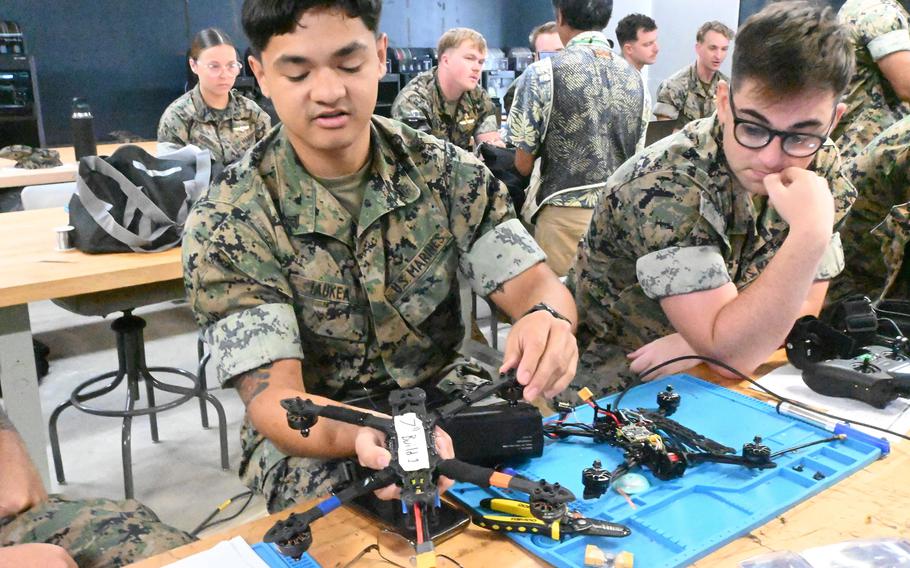 Marines work on repairing drones.
