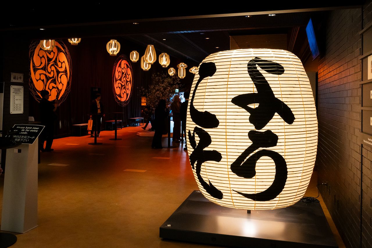 A giant paper lantern and huge noren usher guests into a parallel world. (© Nippon.com)